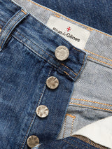Close-up of the Blue de Gênes Giacomo Osaka Jeans in dark denim, featuring visible metal buttons and a fabric label with the brand name. These Italian-made jeans showcase premium rigid denim construction with orange stitching, a partially open fly, and meticulous craftsmanship.