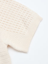 Close-up of the Blue de Gênes BGbilly S/S Cardigan in Chalk—a cream-colored, short-sleeved knit sweater featuring a textured, perforated pattern and ribbed cuffs, laid flat on a white background.