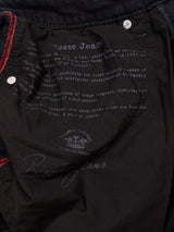 Close-up of the inner pocket of Recco BlueBlk Jeans - Blue Black Denim by Blue de Gênes, featuring red and green stitching, printed text about the jeans, and a signature-style logo at the bottom.