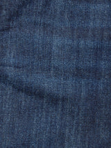 Close-up of the textured, dark blue rigid denim fabric of the Giacomo Dark Horse Jeans in Denim Blue by Blue de Gênes, highlighting the classic woven twill pattern with subtle variations in indigo shading and a faint diagonal crease across the lower section.