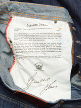 The interior of the Giacomo Dark Horse Jeans – Denim Blue by Blue de Gênes reveals a white pocket lining printed with a history of jeans, the Blue de Gênes logo, and the Giacomo Jeans signature. Orange and red stitching detail the fabric edges. These relaxed loose fit jeans are crafted from rigid denim and proudly made in Italy.