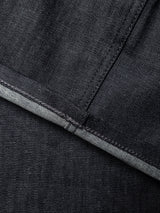 Close-up of Blue de Gênes BGleroy Jeans - Raw Denim fabric, featuring a seam and the edge of a folded hem with visible stitching and lighter-colored inner denim lining, highlighting the innovative construction of these premium five-pocket jeans.