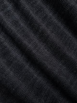 Close-up of black textured fabric with diagonal lines and subtle folds, showcasing the fine weave details and soft, matte finish of Blue de Gênes BGleroy Jeans - Raw Denim—exemplifying the innovative denim construction typical of five-pocket jeans with no outer leg seam.