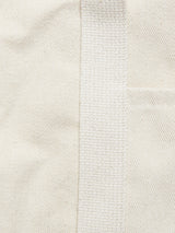 Close-up of the BDG Canvas Bag - Off White by Blue de Gênes, highlighting the cream-colored canvas texture, vertical woven strap, and a small pocket.