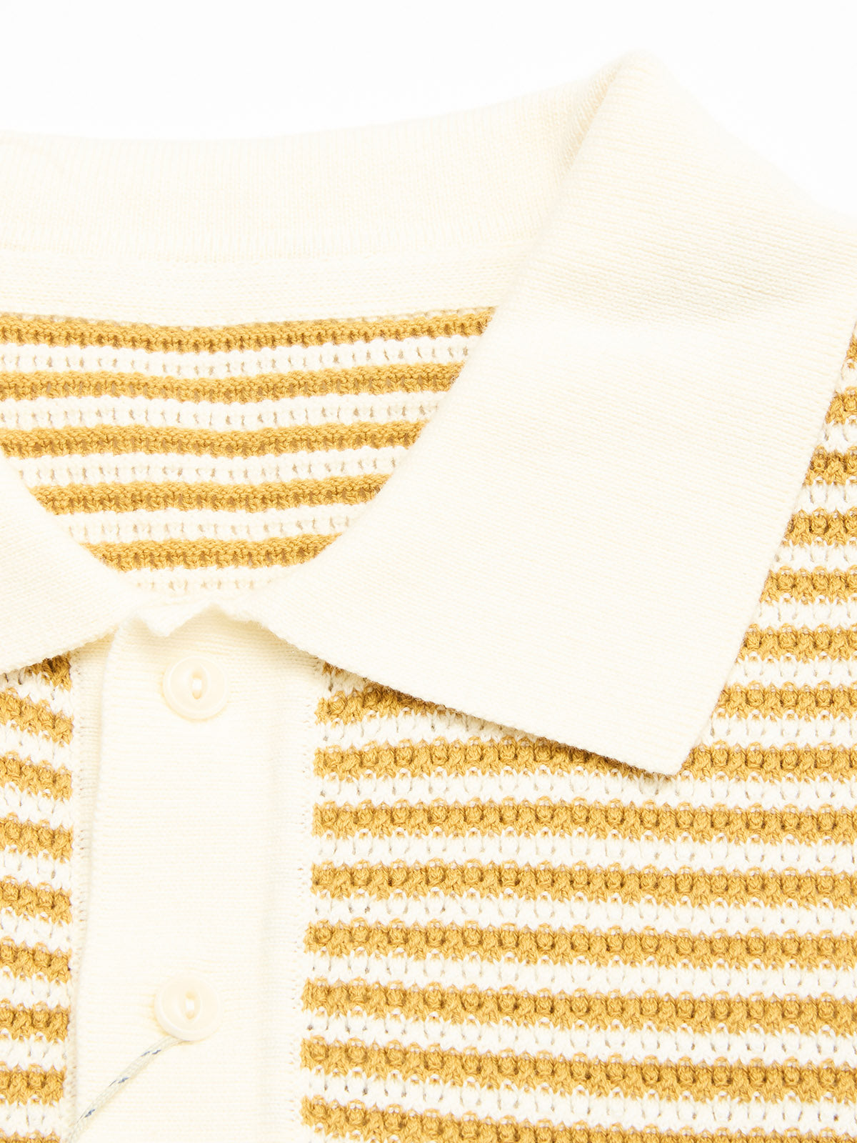 Close-up of the BGbob Knit Polo - Sunflower by Blue de Gênes, a cream cotton knit polo featuring horizontal tan and white textured stripes and white buttons on the front placket.