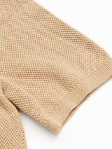 Close-up of the sleeve of the Blue de Gênes Filo Knit Polo in khaki, featuring a textured waffle-knit pattern and ribbed cuff, shown against a white background.