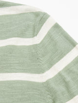 Close-up of Blue de Gênes’ Monte Stripe Knit - Green Bay, featuring green and white stripes with a seam joining two pieces diagonally.