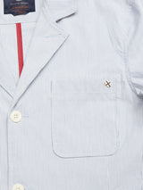 The Gabbiano Riga Blazer by Blue de Gênes features light blue and white stripes, a chest pocket with a small stitched emblem, cream buttons, and a relaxed fit. A glimpse of its red-striped lining makes it an ideal summer choice.