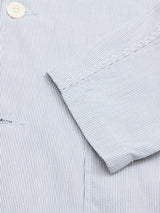 Close-up of the Blue de Gênes Gabbiano Riga Blazer in blue stripe, featuring fine pinstripes, an off-white button, collar and sleeve details, and a relaxed fit for effortless summer style.