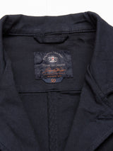 Close-up of the Gabbiano Dobby Blazer - Dark Navy by Blue de Gênes, showing the neatly folded collar, "Blue de Gênes" label, size 50 in orange stitching, cotton comfort stretch fabric, and visible seams.