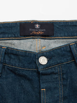 Close-up of the waistband and button on Vinci Topaz Jeans - Rinse Wash by Blue de Gênes, made from stretch denim with a metal button and an orange-stitched Blue de Gênes label.