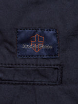 A navy fabric tag with an orange shield logo and silver "Blue de Gênes" text is sewn above the pocket on the Mustang Cargo Pant - Navy.