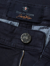 Close-up of the Blue de Gênes Menzo Dobby Chino - Dark Navy, featuring a branded metallic button, partially open zipper, and inner fabric label—ideal for those who appreciate vintage-style chinos.