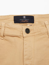 Close-up of the waistband and button on Blue de Gênes Menzo Dobby Chino - Khaki. Features a branded label with crest, belt loops, front pockets, and vintage look in comfort stretch cotton.