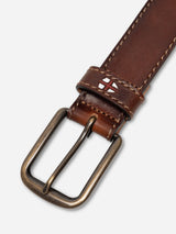 A close-up of the BGualan Belt - Brown by Blue de Gênes, handmade in Italy from full-grain leather, featuring white stitching, a classic metal buckle, and a small England flag emblem near the loop.