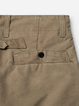 Close-up of the BGliam Nebraska Chino in Brown by Blue de Gênes, highlighting the cotton waistband, belt loop, and back pocket with button closure. Visible stitching complements the smooth, subtly lustrous fabric.