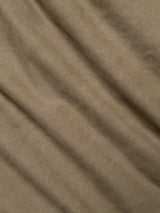 Close-up of light brown fabric with soft, diagonal folds and subtle shadows, revealing the texture and natural creases characteristic of the BGliam Nebraska Chino - Brown by Blue de Gênes, crafted with a fine dobby weave.