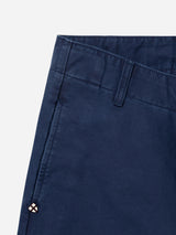 Close-up of the upper section of the BGliam Nebraska Chino - Blue by Blue de Gênes, featuring a side pocket, belt loop, prominent stitching, and a small diamond-shaped logo near the pocket. The high-density dobby weave in these navy blue cotton chinos provides a subtle texture for an elevated finish.