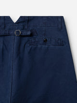 Close-up of the BGliam Nebraska Chino - Blue by Blue de Gênes, crafted from navy blue cotton with a high-density dobby weave for enhanced texture and durability. Features include a back pocket with button closure, a waistband with an adjustable buckle strap, and a small V-shaped notch at the center-back of the waistband.