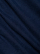 Close-up of dark blue fabric from the BGliam Nebraska Chino - Blue by Blue de Gênes, showcasing soft folds and subtle texture created by a high-density dobby weave, which forms gentle diagonal lines across the material.