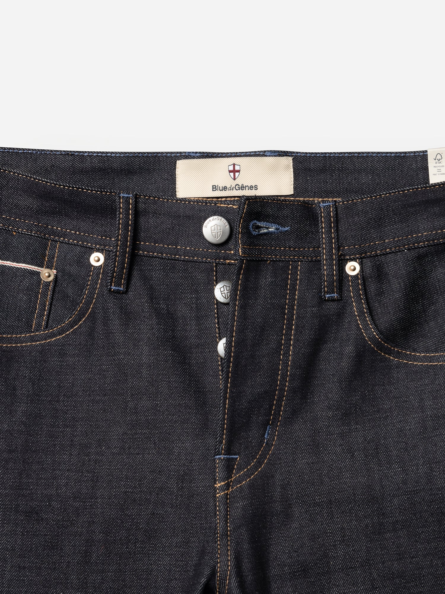 Close-up of rigid dark indigo Blue de Gênes BGgiacomo Selvedge V3 Jeans - Raw Denim featuring a button fly and a branded waistband label.