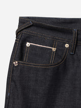 Close-up of the front pocket area of Blue de Gênes BGgiacomo Selvedge V3 Jeans in raw denim, featuring dark blue durable fabric, gold stitching, metal rivets, and a small decorative metal detail near the pocket.