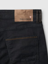 Close-up of the waistband and pocket of the BGpaulo Pavia V3 Chino - Black, featuring black cotton stretch fabric with orange contrast stitching and a leather-look brand patch.