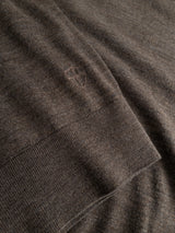 Close-up of the BGigor Polo Knit in Sepia Tint Brown by Blue de Gênes, featuring fine-gauge knit fabric with a small embroidered shield logo near the edge of a ribbed cuff.
