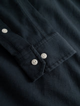 A close-up of the BGenrico Tessusto Shirt - Navy by Blue de Gênes, showcasing its honeycomb textured sleeve with two white corozo buttons on the cuff and one button on the cotton button-down front.