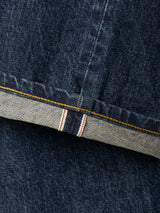 Close-up of the BGmarco Cast Jeans - Denim wash by Blue de Gênes, featuring blue cotton denim fabric with a visible selvedge edge, highlighted by a yellow stitching line and red and white stripes on the inside hem.