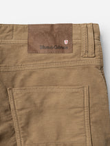 Close-up of sepia tint brown BGpaulo Ottawa V3 Trousers by Blue de Gênes in a regular slim fit, highlighting the back pocket and a brown leather patch with the Blue de Gênes name and a small shield emblem above the right pocket. The texture of the dobby corduroy fabric and detailed stitching are clearly visible.