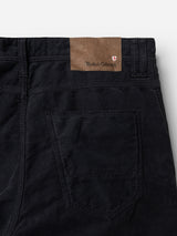 Close-up of the back pocket area of the BGpaulo Ottawa V3 Trousers in dark navy, crafted by Blue de Gênes. Featuring a brown leather patch with the brand’s logo and a small shield emblem above the pocket, these slim fit corduroy trousers blend modern style with timeless detailing.