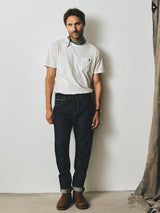 A man wearing a white pocket t-shirt and cuffed, relaxed loose fit BGgiacomo Selvedge V3 Jeans - Raw Denim.