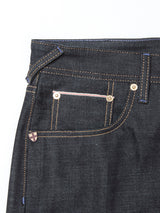 Close-up of the Giacomo Selvedge V2 Jeans by Blue de Gênes, featuring rigid raw denim, front and coin pockets with white and pink stitching, bronze rivets, a visible belt loop, and contrasting yellow stitching.
