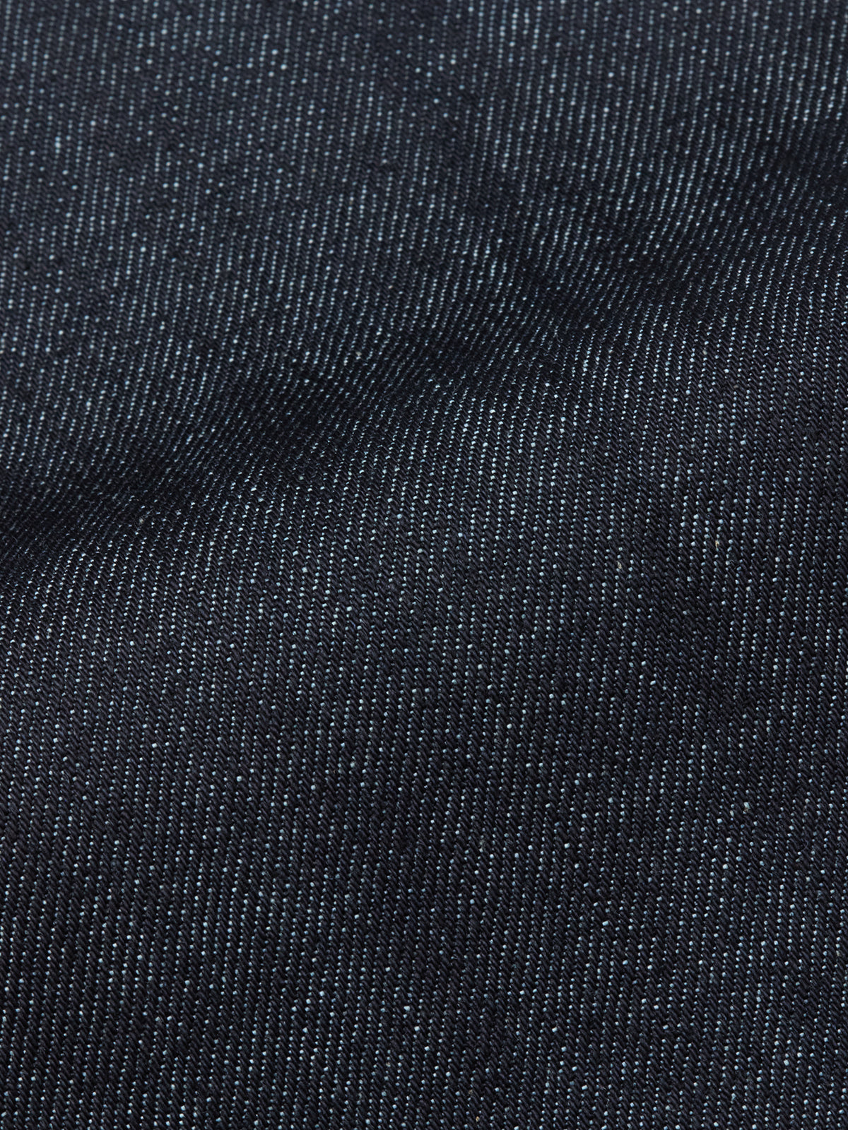 Close-up of Blue de Gênes Giacomo Selvedge V2 Jeans in raw denim, highlighting dark blue fabric with white stitching and a slightly wrinkled finish—hallmarks of quality Italian-made rigid jeans.