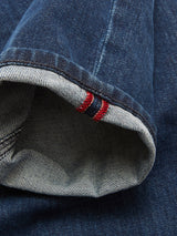 A close-up of the cuff on Vinci Used Jeans - Used by Blue de Gênes, regular fit and made in Italy from dark blue selvedge denim, featuring a visible white edge and red stitching detail.