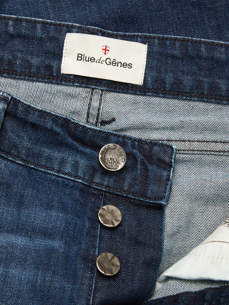 Close-up of Vinci Used Jeans by Blue de Gênes in blue regular fit, featuring three undone metallic buttons and an inner waistband label with a red-and-white crest. Made from comfort stretch denim for all-day ease.