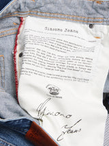 Close-up of the inside pocket of Giacomo Osaka Jeans - Dark Denim by Blue de Gênes, showing a white label with brand history details and a brown leather patch with the brand name on the waistband.