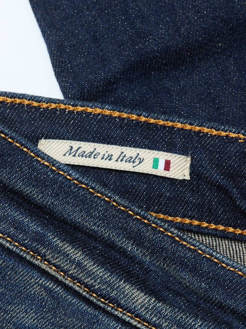 Close-up of a Blue de Gênes label reading Made in Italy, featuring a small Italian flag, sewn onto Repi Dark Vintage Jeans - Mid Blue Denim with comfort stretch and visible yellow stitching.