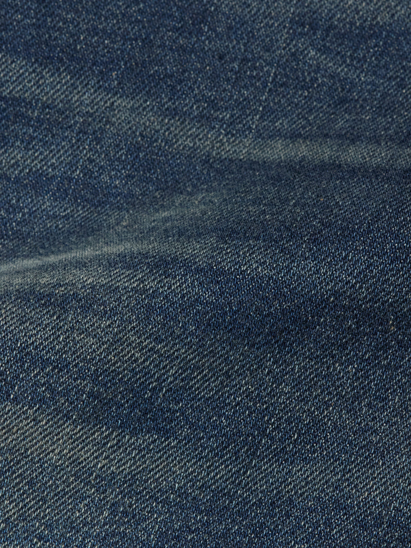 Close-up of Blue de Gênes Repi Dark Vintage Jeans in mid blue denim highlights the comfort stretch fabric’s detailed weave, subtle color variations, and gentle creasing typical of quality craftsmanship.