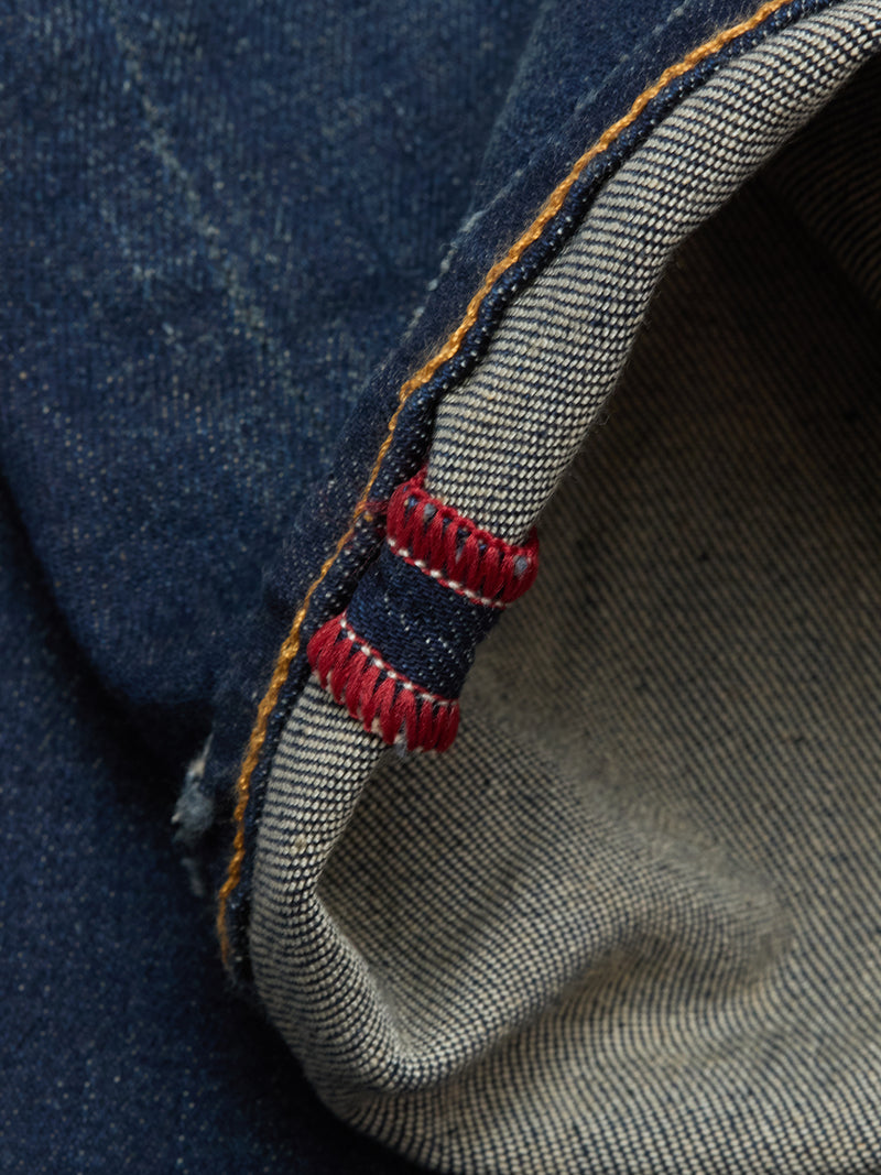 Close-up of the cuff on Blue de Gênes Repi Dark Vintage Jeans in mid blue denim, folded to show the tightly woven white inner fabric with red and blue stitching detail.