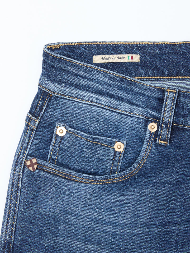 Close-up of Recco Blue Vintage Jeans - Vintage Wash by Blue de Gênes, showing the front pocket with gold rivets and stitching. The waistband label features Made in Italy with an Italian flag. Relaxed fit for effortless comfort.