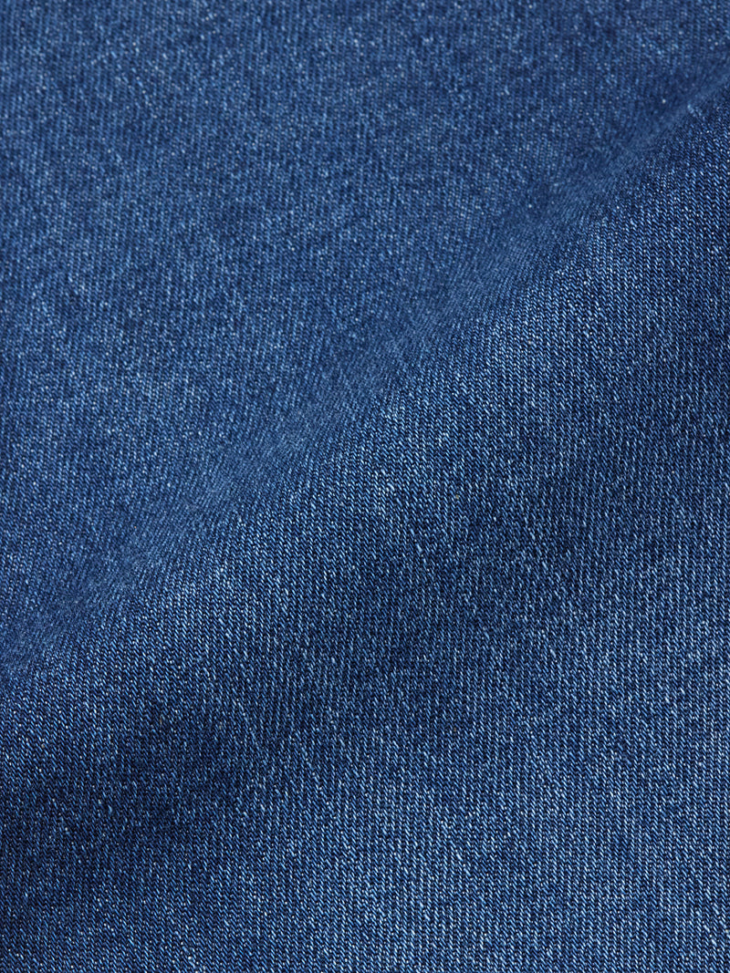Close-up of Recco Blue Vintage Jeans - Vintage Wash by Blue de Gênes, highlighting the detailed weave pattern and texture of the blue denim fabric with a diagonal seam visible.