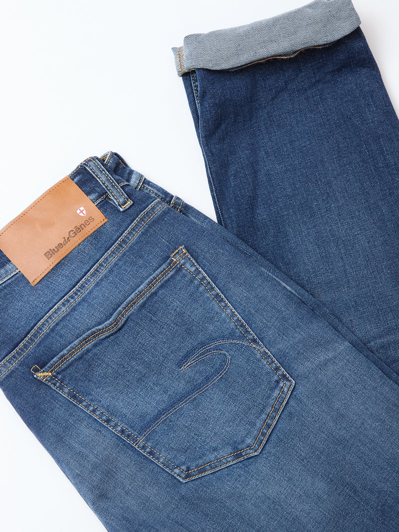The Recco Blue Vintage Jeans - Vintage Wash by Blue de Gênes feature a brown leather label, visible back pocket stitching, and turned-up cuffs revealing lighter inner fabric—ideal for fans of relaxed fit styles.