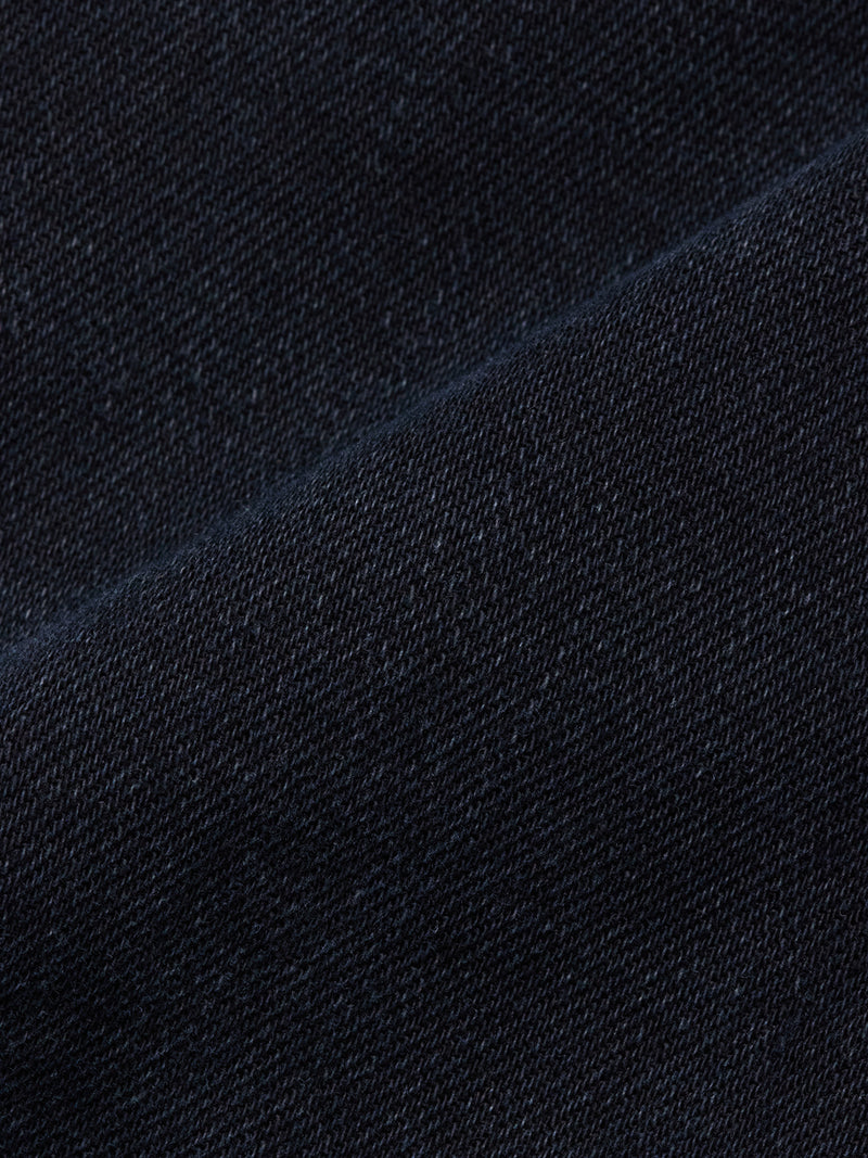 Close-up of the Blue de Gênes Recco BlueBlk Jeans in blue black denim, featuring a visible diagonal seam and intricate weave that highlight the premium texture of these tapered leg jeans.