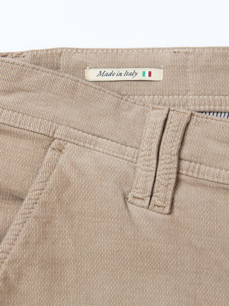 Close-up of Blue de Gênes BGpaulo Ottawa Trousers in Fungi, featuring beige dobby corduroy fabric with a belt loop, front pocket, and a "Made in Italy" fabric label accented by a small Italian flag.