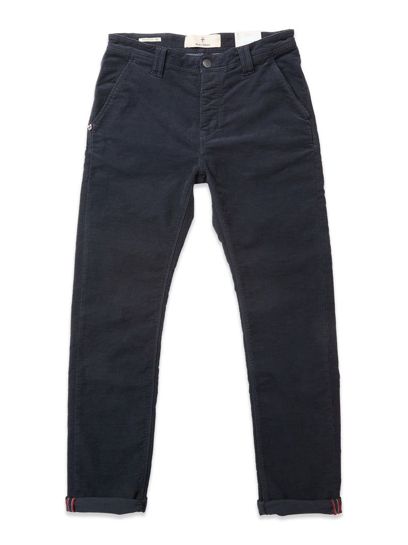 The BGpaulo Ottawa Trousers by Blue de Gênes are dark navy corduroy chinos featuring side and back pockets, button and zipper closure, and rolled cuffs with red and navy stripes. Shown laid flat on a white background.