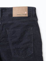 Close-up of the back of BGpaulo Ottawa Trousers in dark navy by Blue de Gênes, featuring a single back pocket and a tan leather patch with the brand name and red and white shield logo, made in Italy.