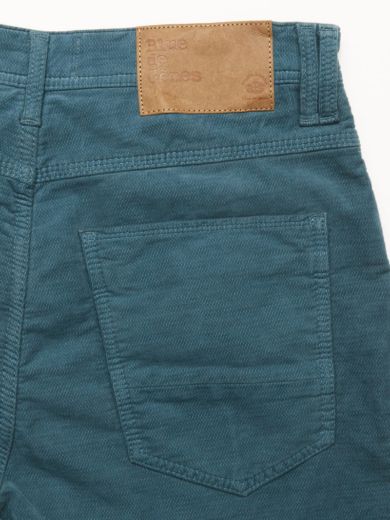 Close-up of the back pocket of Dark Slate BGpaulo Ottawa Trousers by Blue de Gênes, featuring a brown leather patch above the pocket with embossed Blue de Gênes branding.