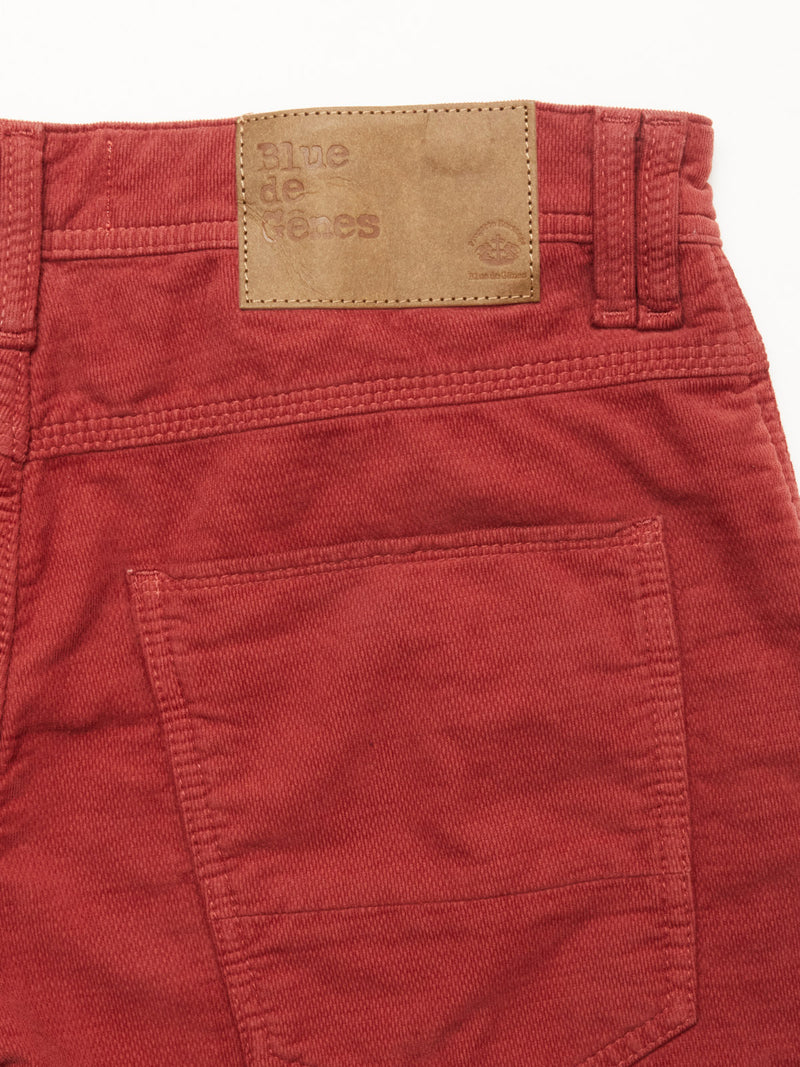 Close-up of the back pocket and waistband of BGpaulo Ottawa Trousers - Henna by Blue de Gênes, featuring a brown leather patch embossed with the brand name above the pocket.